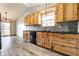 Kitchen featuring wood cabinets, black countertops, and stainless steel dishwasher at 7230 Carrie Dr, Indianapolis, IN 46237