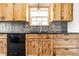 Updated kitchen with wood cabinets, black countertops, and stainless steel sink at 7230 Carrie Dr, Indianapolis, IN 46237