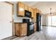 Kitchen with wood cabinets, black appliances, and access to the living area at 7230 Carrie Dr, Indianapolis, IN 46237
