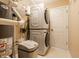 Laundry room with a stacked washer/dryer, water heater, water softener, and white vinyl floors at 7230 Carrie Dr, Indianapolis, IN 46237