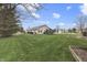 Expansive backyard with lush green space, trampoline, garden beds, and serene suburban views at 7441 Sugar Pine Ct, Avon, IN 46123