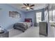 Cozy bedroom featuring a ceiling fan, blue walls, and natural light at 7441 Sugar Pine Ct, Avon, IN 46123