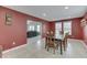 Inviting dining area with red walls, tiled floor, wood table with chairs, connecting to the living room at 7441 Sugar Pine Ct, Avon, IN 46123