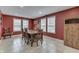 Elegant dining room with red walls, tile flooring, and a wooden table with seating for six at 7441 Sugar Pine Ct, Avon, IN 46123