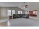 Expansive living room with plush carpeting, ceiling fan, and a comfortable leather sectional sofa, leading to the dining room at 7441 Sugar Pine Ct, Avon, IN 46123