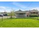A fenced-in yard has green grass and a view of the detached garage with space for parking at 844 Blanchard St, Shelbyville, IN 46176