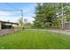 A fenced-in backyard has a green lawn and a view of the detached garage and neighboring properties at 844 Blanchard St, Shelbyville, IN 46176