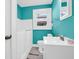 This blue bathroom has a walk in bathtub and shower, vanity and tile floors at 87 S 10Th Ave, Beech Grove, IN 46107