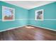 This bedroom features bright blue walls, laminate floors, and two windows at 87 S 10Th Ave, Beech Grove, IN 46107