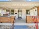 Inviting covered front porch with brick columns and porch swing for relaxing outdoors at 87 S 10Th Ave, Beech Grove, IN 46107