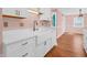 Bright and modern kitchen featuring white cabinets, stylish hardware, and a farmhouse sink at 87 S 10Th Ave, Beech Grove, IN 46107
