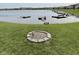 Lakeside backyard showing a fire pit surrounded by green grass and docks at 8755 Stoddard Ln, Indianapolis, IN 46217