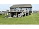 Spacious two-story home with a second-story deck, patio, stairs, and green lawn at 8755 Stoddard Ln, Indianapolis, IN 46217