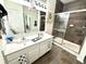 Bathroom featuring a double sink vanity with wood tile floors and glass enclosed shower at 8755 Stoddard Ln, Indianapolis, IN 46217