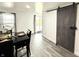 Cozy dining area featuring a modern sliding barn door and natural light from an exterior door at 8755 Stoddard Ln, Indianapolis, IN 46217