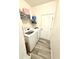 Laundry room equipped with a washer, dryer, storage shelf, and a white door at 8755 Stoddard Ln, Indianapolis, IN 46217