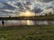 Picturesque pond reflecting the setting sun, surrounded by green grass and trees at 8755 Stoddard Ln, Indianapolis, IN 46217