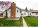 Landscaped backyard featuring manicured lawn and charming home with brick chimney at 905 E Yoke St, Indianapolis, IN 46203