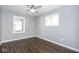 This bedroom features dark laminate flooring, a ceiling fan, and a view to the backyard at 905 E Yoke St, Indianapolis, IN 46203