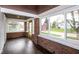 Sunlit enclosed porch featuring hardwood floors, brick accents, and expansive windows showcasing the outdoor scenery at 905 E Yoke St, Indianapolis, IN 46203
