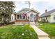 Quaint home featuring a brick facade, freshly cut grass, and a welcoming walkway leading to the front door at 905 E Yoke St, Indianapolis, IN 46203