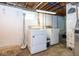 A functional laundry room with washer, dryer, utility sink, and block glass window at 905 E Yoke St, Indianapolis, IN 46203