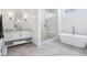 Well-lit bathroom featuring a glass shower, a soaking tub, and a stylish vanity with a large mirror at 961 Starkey Rd, Zionsville, IN 46077
