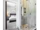 Stylish bathroom featuring a glass walk-in shower with pebble floor and a view into the bedroom at 961 Starkey Rd, Zionsville, IN 46077