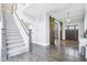 Elegant foyer featuring a staircase, hardwood floors, and a rustic sliding barn door leading to an office at 961 Starkey Rd, Zionsville, IN 46077
