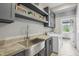 Well-lit laundry room featuring gray cabinets, a stainless steel sink, and modern appliances for a clean and organized space at 961 Starkey Rd, Zionsville, IN 46077