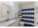 Cozy bathroom featuring a vanity with gray countertop, glass shelving, and a striped shower curtain at 9664 Trail Dr, Avon, IN 46123