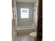 Bathroom with tub, toilet, pedestal sink, and frosted window at 1105 N Livingston Ave, Indianapolis, IN 46222