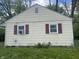 A close-up of a home's exterior showing a window unit, red shutters, and horizontal siding at 1105 N Livingston Ave, Indianapolis, IN 46222