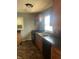 Kitchen featuring wood cabinets, stainless steel sink, black appliances, and tile floor at 1105 N Livingston Ave, Indianapolis, IN 46222