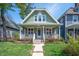 Charming home with a welcoming front porch, lush landscaping, and a freshly painted exterior at 1217 Evison St, Indianapolis, IN 46203