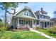 Charming home with a welcoming front porch, lush landscaping, and a freshly painted exterior at 1217 Evison St, Indianapolis, IN 46203