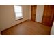 A small bedroom with wood-look flooring and natural light from a window at 12731 Slippery Rock Rd, Indianapolis, IN 46236