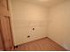 Laundry room with white walls, wood-look flooring, and a single shelf at 12731 Slippery Rock Rd, Indianapolis, IN 46236