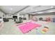 Expansive basement with gymnastics equipment, couches, and tv area all featuring light gray carpet and light gray walls at 12959 Girvan Way, Fishers, IN 46037