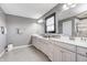 Dual vanity bathroom with gray walls, white marble countertops and a large mirror at 12959 Girvan Way, Fishers, IN 46037