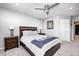 This carpeted bedroom features a ceiling fan, wooden bed frame, gray walls, and a white door at 12959 Girvan Way, Fishers, IN 46037