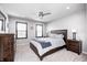 This carpeted bedroom features a ceiling fan, wooden bed frame, gray walls and two windows with horizontal blinds at 12959 Girvan Way, Fishers, IN 46037