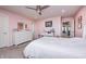 Spacious pink bedroom with ceiling fan, desk, and dresser, providing a cheerful and functional space at 12959 Girvan Way, Fishers, IN 46037