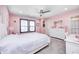 Bright pink bedroom features a white bed frame, ceiling fan, and a large window at 12959 Girvan Way, Fishers, IN 46037