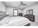 Relaxing gray bedroom includes a ceiling fan, neutral walls, and dark furniture at 12959 Girvan Way, Fishers, IN 46037