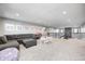 Open bonus room with gray sectional, play area, and easy access to the stairs at 12959 Girvan Way, Fishers, IN 46037