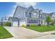 Charming two-story home with well-manicured landscaping, a three-car garage, and blue siding at 12959 Girvan Way, Fishers, IN 46037