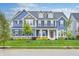 Charming two-story blue home with well-manicured lawn, tasteful landscaping, and welcoming front porch at 12959 Girvan Way, Fishers, IN 46037