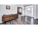 Hallway with hardwood floors, a modern wood dresser, and an office in the background at 12959 Girvan Way, Fishers, IN 46037
