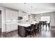 Well-lit kitchen with stainless steel appliances, kitchen island with barstool seating, and tile backsplash at 12959 Girvan Way, Fishers, IN 46037